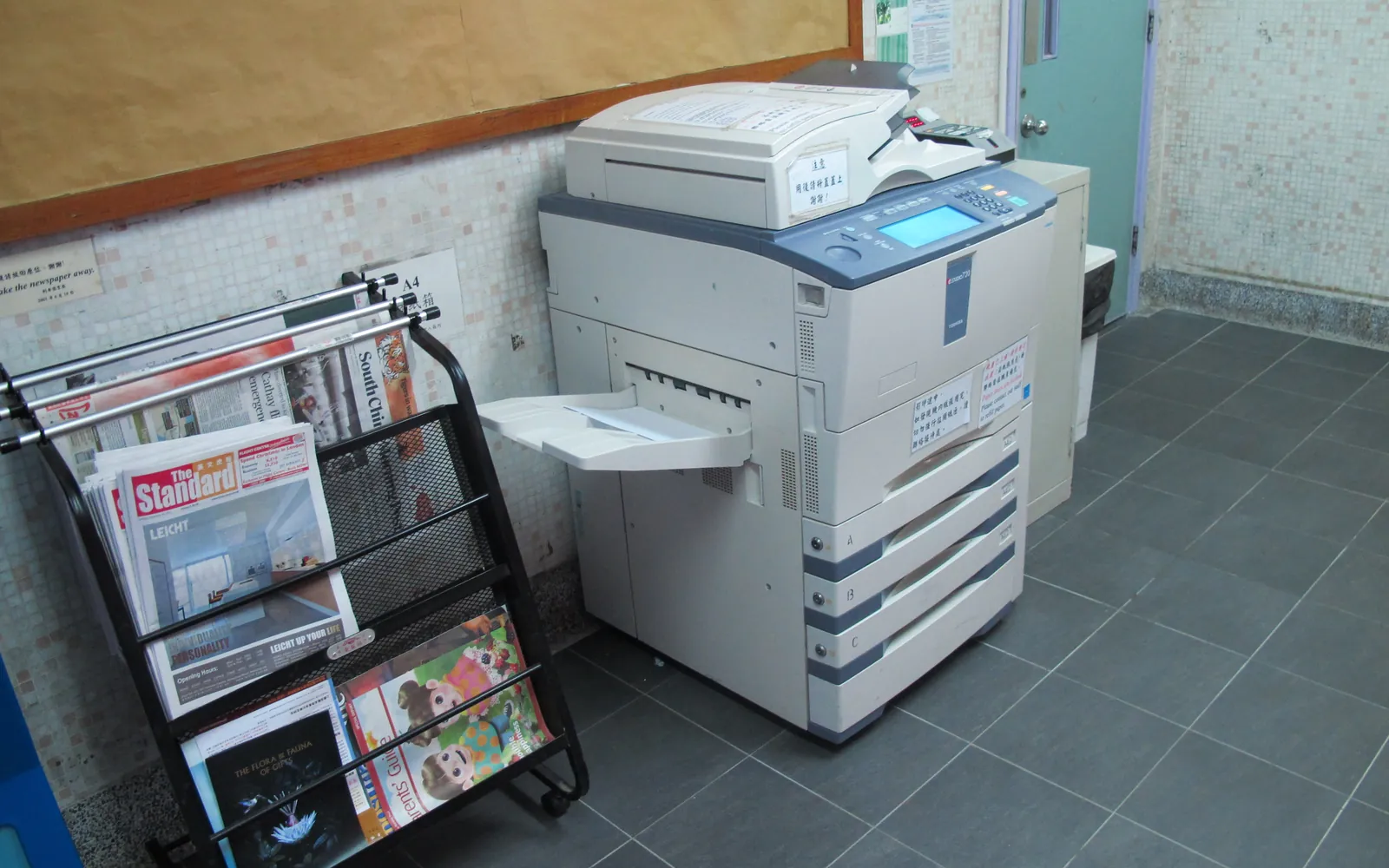 A floor-standing multifunction copier and printer in a small shop